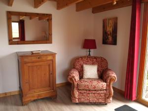 a chair in a room with a mirror and a lamp at Acacia in Cherbonnières