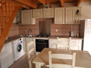 a kitchen with white cabinets and a table and chairs at Acacia in Cherbonnières +39 photos