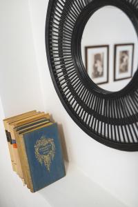 a stack of books sitting next to a mirror at BLAHA ROOMS in Balatonfüred