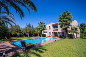een villa met een zwembad en een huis bij Villa 'Cartier' in Marrakesh