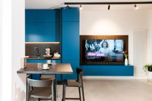 a kitchen with blue walls and a table and a tv at Aschitelli luxury retreat in Polignano a Mare