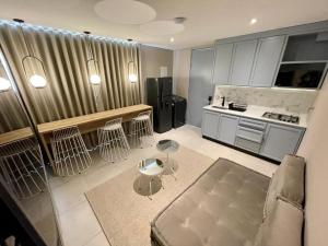 a living room with a kitchen with a counter and a stove at Hotel Dix in Medellín