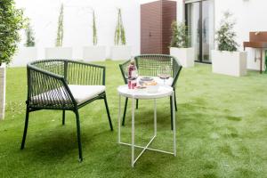 two chairs and a table with a plate of food on the grass at Aschitelli luxury retreat in Polignano a Mare
