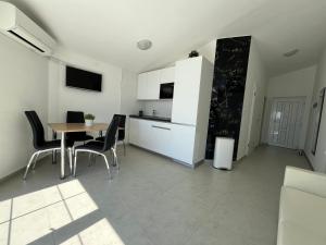 kuchnia i jadalnia ze stołem i krzesłami w obiekcie Mirakul Apartments w mieście Vir +37 zdjęć