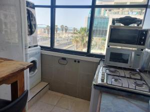 a kitchen with a microwave and a computer on a stove at Aparthotel Banana Beach in Tel Aviv
