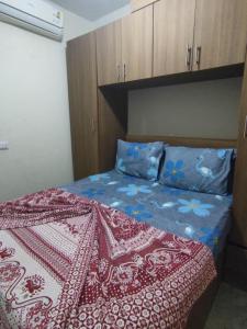 a bedroom with a bed with a red and blue blanket at BTM RENTAL CHALETS PORTO MATROUH FAMiLY ONLY in Marsa Matruh