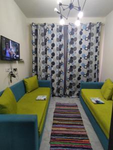 BTM RENTAL CHALETS PORTO MATROUH FAMiLY ONLY في مرسى مطروح: غرفة معيشة مع كنبتين وتلفزيون