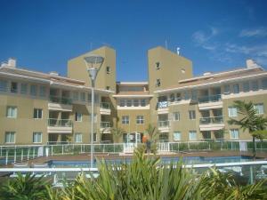 een groot appartementencomplex met een zwembad ervoor bij The Sun Maravilhoso in Brasilia