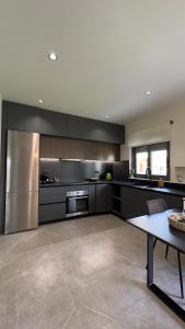 a kitchen with black cabinets and stainless steel appliances at 30 Senses Luxury Apartment Insight in Ialyssos