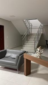 a living room with a couch and a staircase at hotel quatro coracoes in Arapiraca