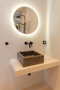 a bathroom with a stone sink with a mirror at Vasilopoulos Residences - Villa Kalliste in Argostoli