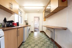 una cucina con armadi in legno e pavimento piastrellato di 4 bedrooms house for working Professionals a Southampton