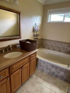 a bathroom with a tub and a sink and a bath tub at View of Ocean & MOUNT BAKER in White Rock +13 photos