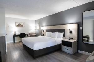 a bedroom with a large white bed and a desk at La Quinta Inn by Wyndham Stockton in Stockton