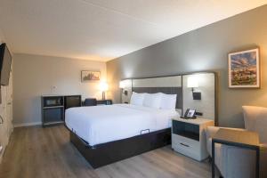 a hotel room with a large bed and a chair at La Quinta Inn by Wyndham Stockton in Stockton