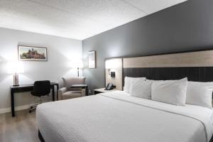 a hotel room with a large bed and a desk at La Quinta Inn by Wyndham Stockton in Stockton