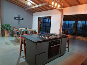 uma cozinha com uma placa de fogão num quarto em cabaña la esmeralda em El Peñol