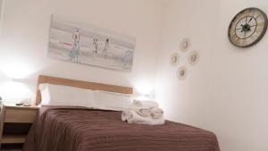 ein Schlafzimmer mit einem Bett und einer Uhr an der Wand in der Unterkunft More Apartments il Ferrarese2 in Bari