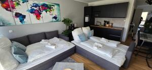 2 camas en una sala de estar con sofá en Design Luxus, Vollausstattung, Neubau, 30min Hbf Leipzig 8, Nähe Flughfaen, BMW, DHL, Amazon, en Schkeuditz