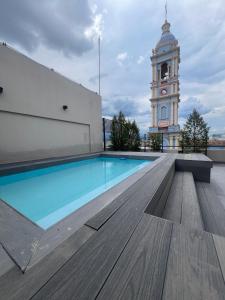 una piscina con una torre de reloj en el fondo en Apartamento Mirador de la Viña. en Salta