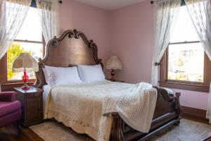 a bedroom with a large bed and two windows at The Pearl Inn Bed and Breakfast in Ilwaco