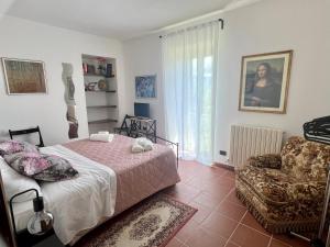 1 dormitorio con 1 cama, 1 silla y 1 ventana en Chez Vittoria, en Greccio