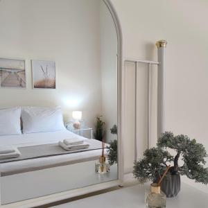 biała sypialnia z łóżkiem i dużym lustrem w obiekcie Preveza Mosaic House w Prewezie +35 zdjęć