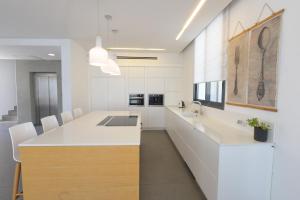una cucina con armadi bianchi e un'isola cucina con lavandino di New ! 430m Luxury Best Top Class 8-Bdr Exclusive Villa Top Design HEATED Pool Jucuzzi Sauna a Eilat