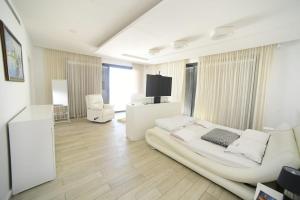 Cette grande chambre blanche dispose d'un lit et d'une télévision. dans l'établissement New ! 430m Luxury Best Top Class 8-Bdr Exclusive Villa Top Design HEATED Pool Jucuzzi Sauna, à Eilat