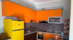 a kitchen with orange cabinets and a yellow refrigerator at Sunset Vista Guesthouse in Vlorë