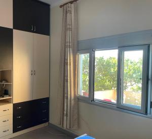 a room with a window and a kitchen with at Sunset Vista Guesthouse in Vlorë