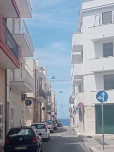 a street with cars parked on the side of a building at Splendore del Sole in Polignano a Mare