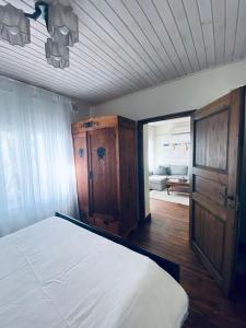 - une chambre avec un lit blanc et une armoire en bois dans l'établissement Antique suburban apartment, à Türi