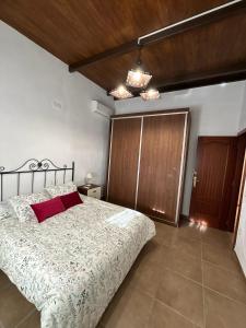 a bedroom with a large bed and a wooden door at Dehesa Elías in Lucena