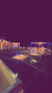 ein Parkplatz mit einem Gebäude in der Nacht in der Unterkunft كوخ القرية أبها 2 in Abha