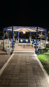 a gazebo with blue and white benches at night at كوخ القرية أبها 2 in Abha