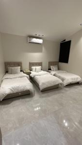 2 camas en una habitación con paredes blancas en كوخ القرية أبها 2, en Abha