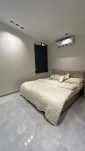 ein großes Bett in einem Zimmer mit einem TV in der Unterkunft كوخ القرية أبها 2 in Abha