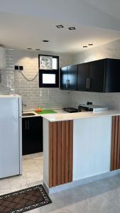 eine Küche mit schwarzen Schränken und einem weißen Kühlschrank in der Unterkunft كوخ القرية أبها 2 in Abha