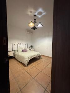 a bedroom with a bed and a ceiling fan at Dehesa Elías in Lucena
