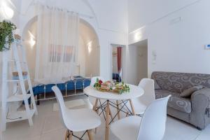 a living room with a table and chairs and a couch at Suite la Perla in Ceglie Messapica