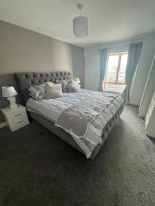 een slaapkamer met een groot bed en een raam bij Luxury 2 bed fully equipped city centre apartment in Cork