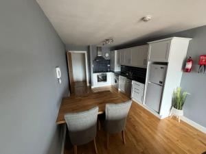 a kitchen with a wooden table and chairs at Luxury 2 bed fully equipped city centre apartment in Cork