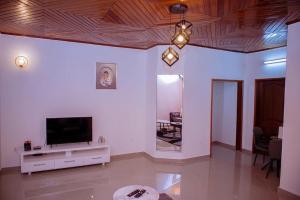 a living room with a flat screen tv on a wall at Ange meublés in Bassa