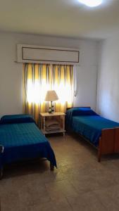 1 dormitorio con 2 camas y mesa con lámpara en Milli en Gualeguaychú