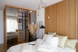 una camera da letto con un letto con cuscini bianchi di D'Art Penthouse a Spalato (Split)