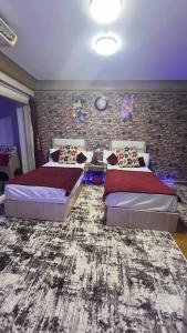 sypialnia z 2 łóżkami i ceglaną ścianą w obiekcie Nile Star Suites & Apartments w Kairze