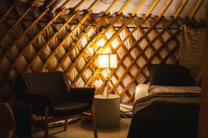 Habitación con cama, silla y lámpara. en Náttúra Yurtel en Haukadalur