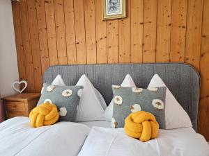 two stuffed animals sitting on top of a bed at Apartment Klein Matterhorn - Haus Miranda in Täsch
