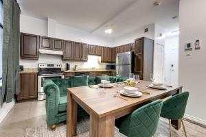 uma cozinha com uma mesa de madeira e cadeiras verdes em M11 Beautiful Cozy 2BR wAC Perfect Location em Montreal